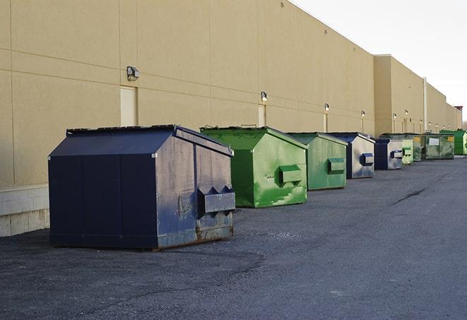 a series of colorful, utilitarian dumpsters deployed in a construction site in Maple Heights